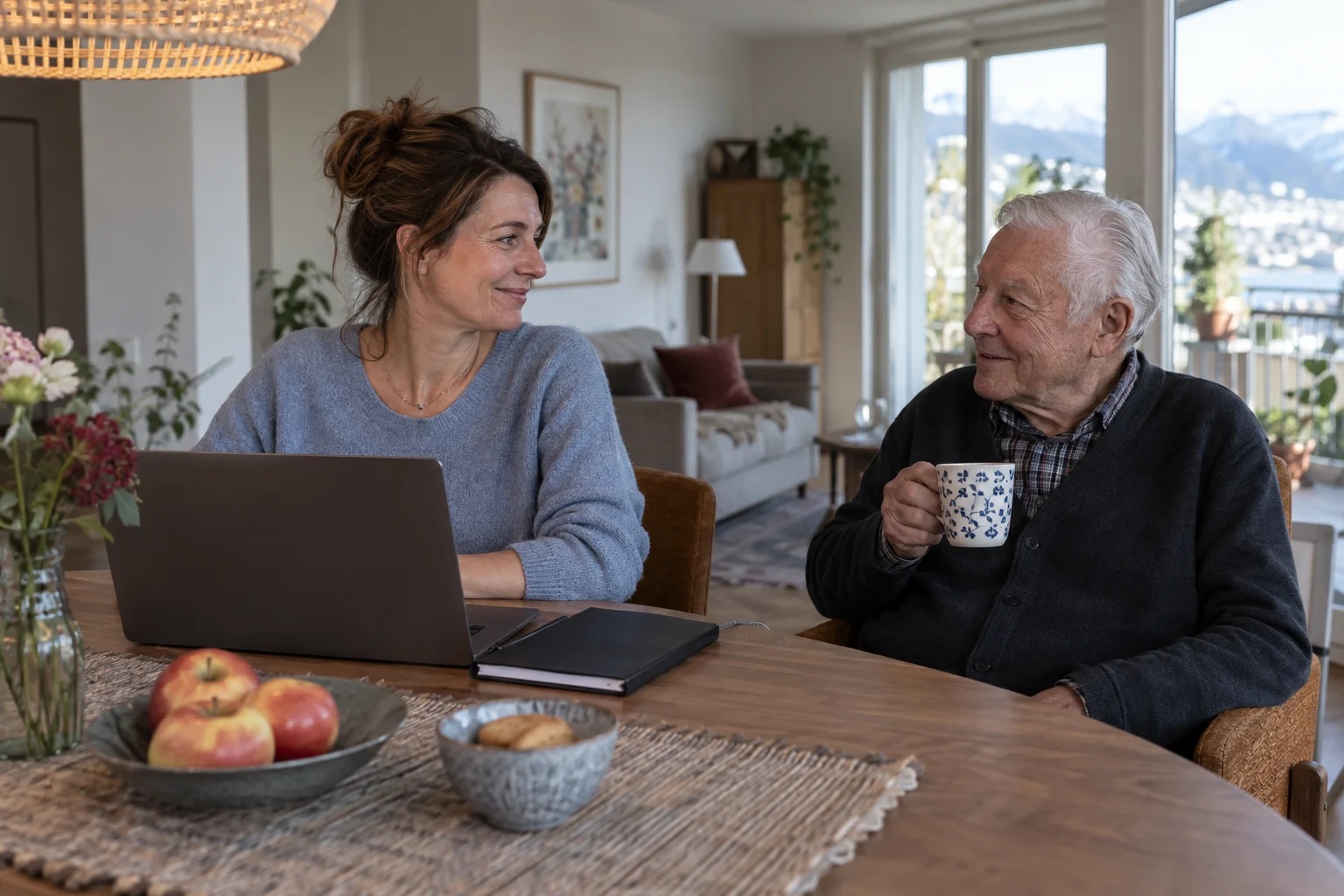 Berufstätige Angehörige am Laptop im Gespräch mit ihrem Vater am Esstisch